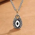 Tibetan Dzi Bead Garuda Pendant Necklace - handmade copper with black-white eye motif on kraft paper background