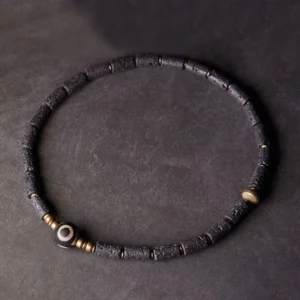 Single wrap tibetan dzi lava rock bracelet top view - minimalist design with three-eye dzi focal bead and brass spacers