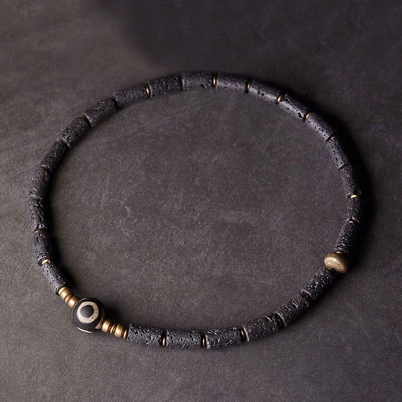 Single wrap tibetan dzi lava rock bracelet top view - minimalist design with three-eye dzi focal bead and brass spacers
