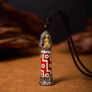 Nine-eye dzi bead pendant shown from right angle displaying protective amulet design with black braided necklace cord