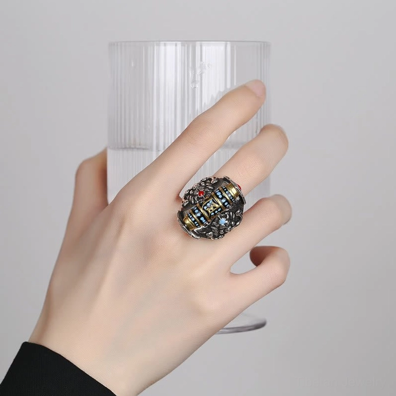 Tibetan Om Mani Padme Hum protection ring worn on finger, showing compact retro silver design with intricate carved Buddhist patterns