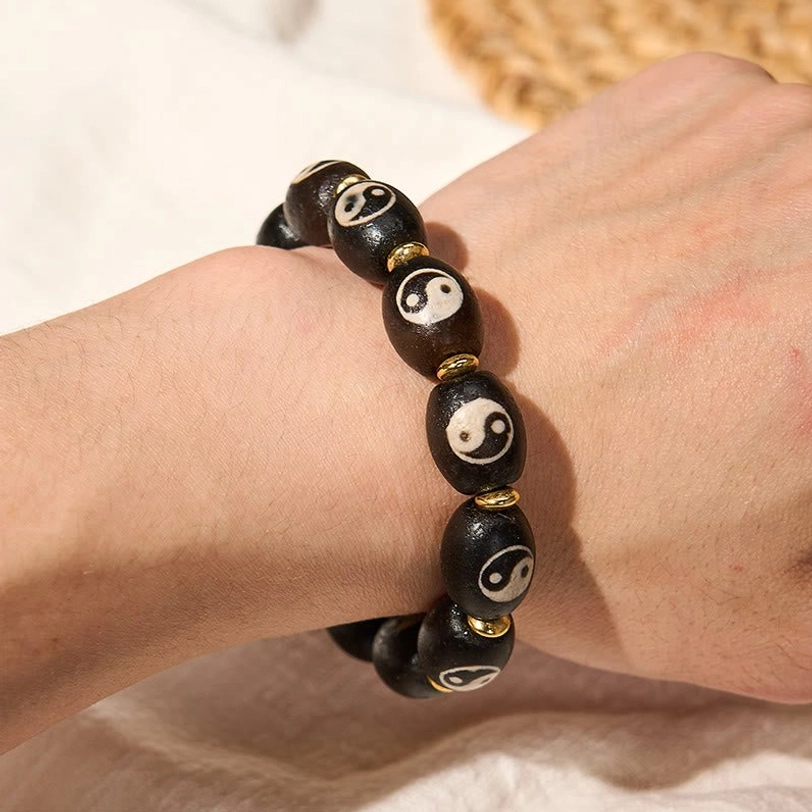 Tibetan protection bracelet lifestyle shot featuring Dzi Bead with Yin Yang motif suitable for spiritual practice, meditation, and daily wellness