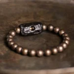 Handcrafted tibetan ebony wood copper balance bracelet with ornate carved spacer bead flat lay overhead view