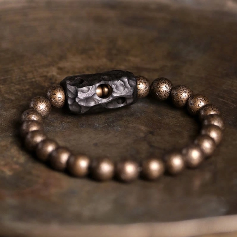 Handcrafted tibetan ebony wood copper balance bracelet with ornate carved spacer bead flat lay overhead view