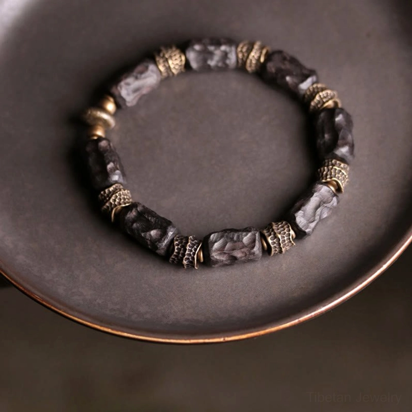 Tibetan ebony wood copper bracelet full circular display on dark metal tray showing mixed bead design from above