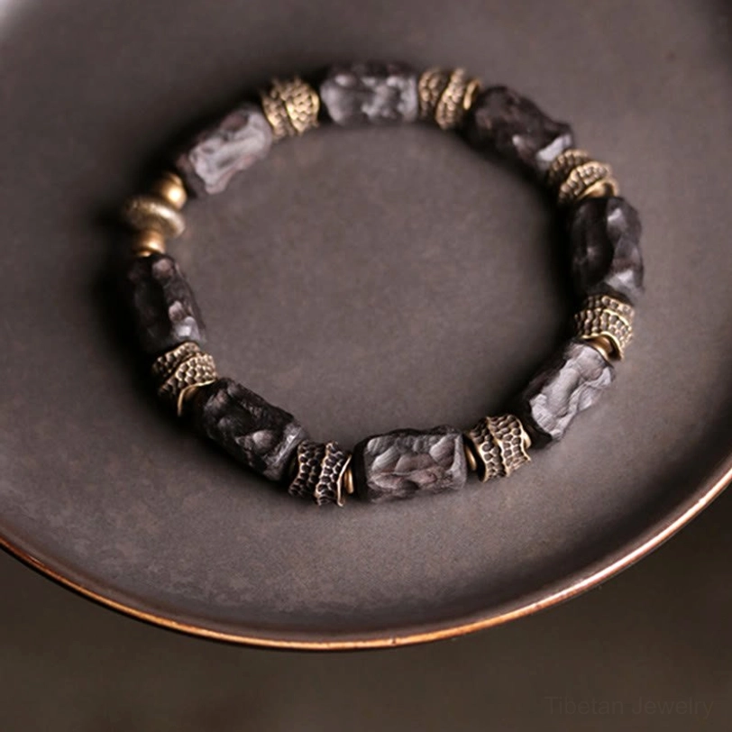 Tibetan ebony wood copper bracelet complete circular mixed bead design displayed on dark tray overhead view