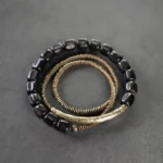 Multilayered Tibetan ebony wood and copper healing bracelet, top-down view showing coiled bead chain design on dark background