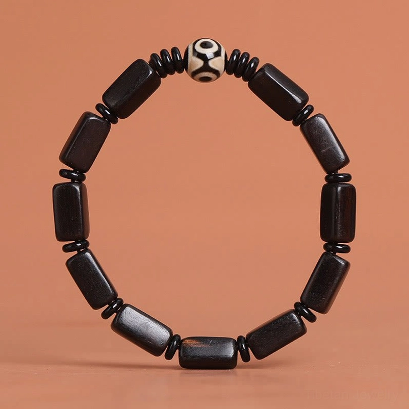 Tibetan protection bracelet lifestyle display featuring Dzi bead and ebony wood beads in natural setting