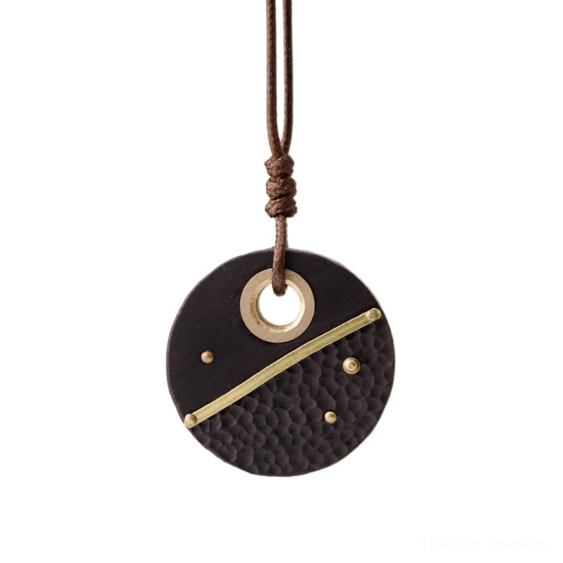 Handcrafted Tibetan ebony wood pendant with traditional brass detailing and spiritual symbolism