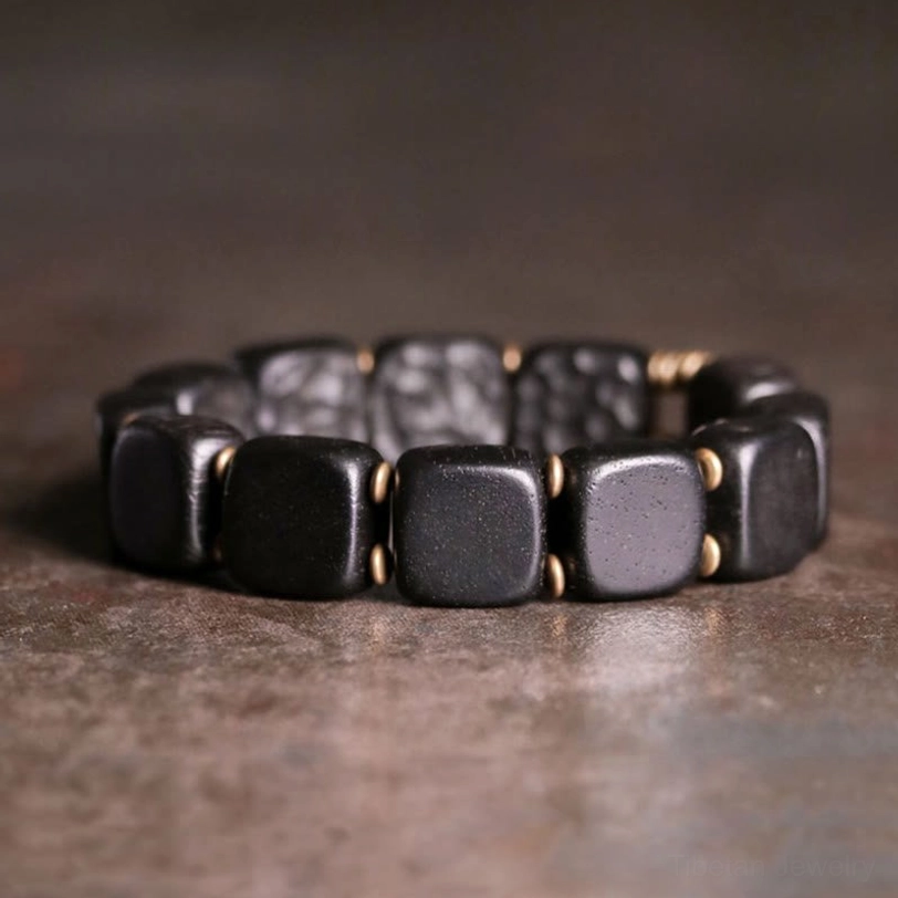 Elevated front view of tibetan balance bracelet with matte black smooth and hammered square beads alternating pattern