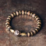 Tibetan ebony wood bone bead bracelet with dzi bead flat lay on vintage tabletop