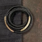 Tibetan ebony wood multilayered bracelet with copper accents, flat lay overhead view showing dark wood disc beads and brass metal details