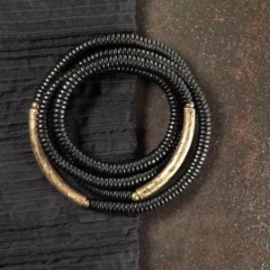 Tibetan ebony wood multilayered bracelet with copper accents, flat lay overhead view showing dark wood disc beads and brass metal details
