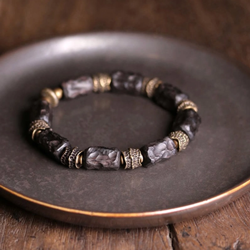 Tibetan ebony wood copper bracelet symmetrical display on dark metal tray showing complete bead sequence overhead angle