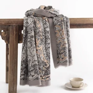 Tibetan ethnic paisley shawl in rosy brown displayed on wooden bench with coffee cup - vintage floral print scarf wrap
