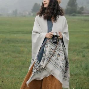 Ethnic Tibetan wrap with tribal geometric print patterns styled with camera accessory in outdoor grassland setting