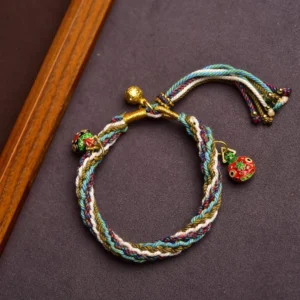 Handmade Tibetan reincarnation knot bracelet featuring blue white olive braided cord with enamel animal charms and gold hardware details