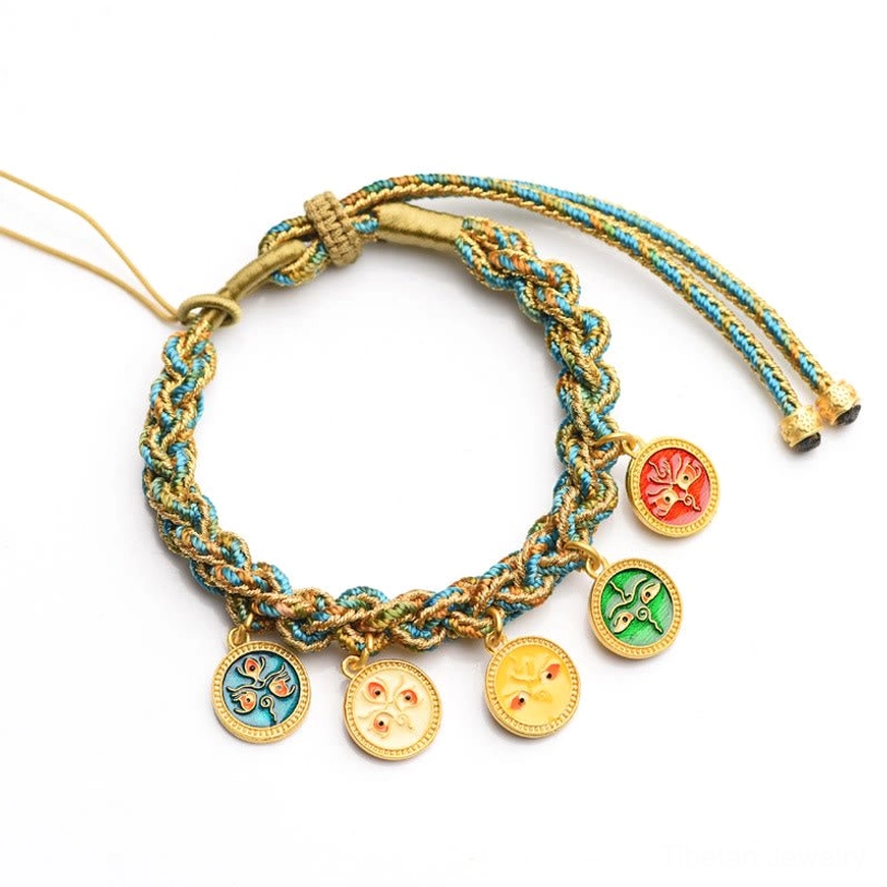 Overhead view of Tibetan wealth braided bracelet displaying five distinct enamel pendants and pull cord adjuster on white background