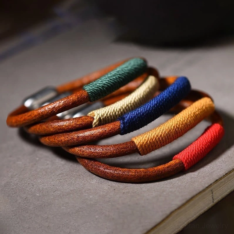 Collection of Tibetan five elements bracelets in multiple colors - red fire, blue water, green wood, beige metal, yellow earth - flat lay display