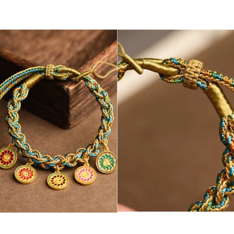 Complete Tibetan Five God of Wealth braided bracelet showing all five fortune enamel charms on wooden block background