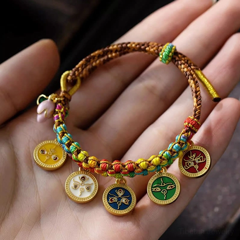 Multicolor woven tibetan wealth bracelet with gold-edged enamel pendants and neat braided knots on palm