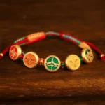 Tibetan five gods of wealth braided rope bracelet with colorful woven cords and multicolored enamel charms displayed on dark wooden surface