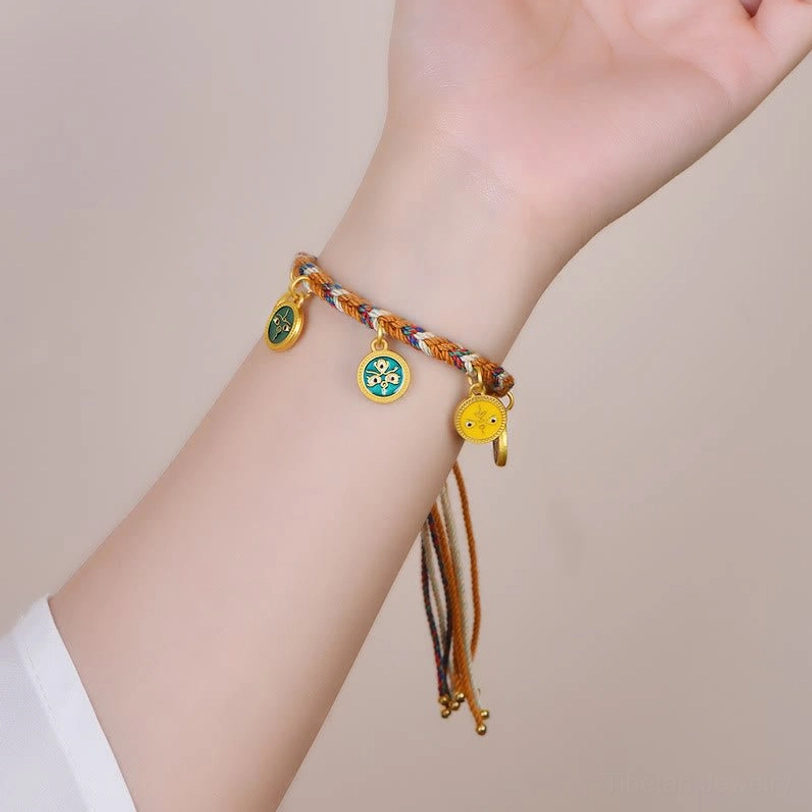 Tibetan five gods of wealth luck bracelet worn on human wrist showing dangling enamel charms and tassel closure in lifestyle setting