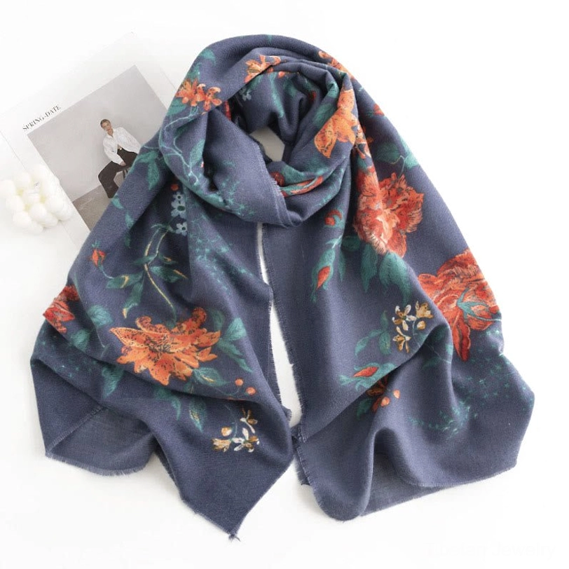 Navy blue Tibetan floral printed scarf with orange and green leaf botanical motifs, displayed in loose draped front three-quarter view