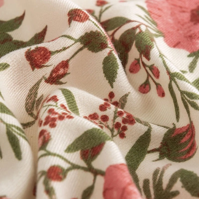 Detailed macro photography of Tibetan floral scarf weave showing wrinkled fabric and clear botanical print quality
