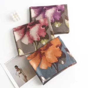 Folded collection of Tibetan floral scarves in multiple earth tone colors showing versatile style options