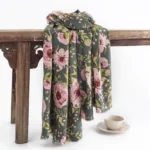 Tibetan floral shawl with pink blooming flowers and green leaves on dark green base - hanging display view
