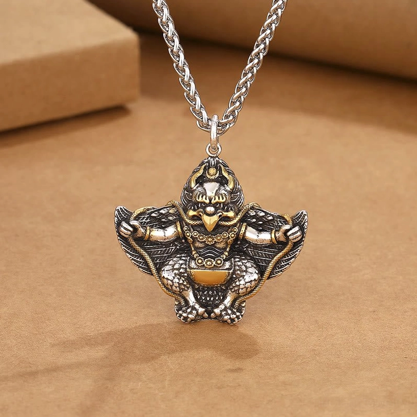Tibetan Garuda Bird copper protection pendant with wheat chain, two-tone silver and gold finish, detailed carved deity design, overhead view