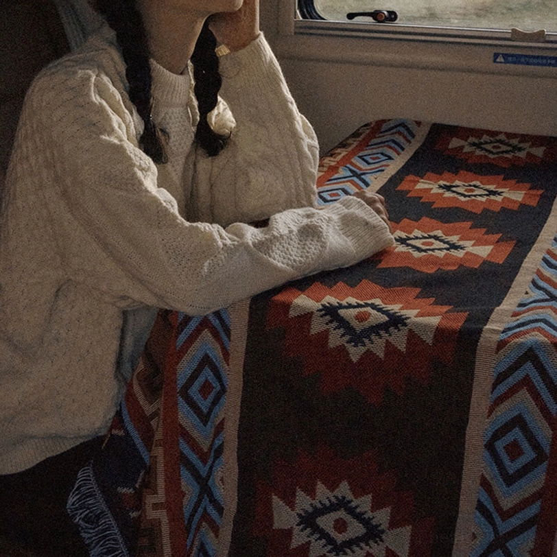 Tibetan geometric blanket covering camper van table interior showing tribal pattern design in travel van lifestyle setting