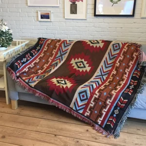 Tibetan geometric hand-woven throw blanket with multi-color tribal patterns displayed on sofa with fringe details