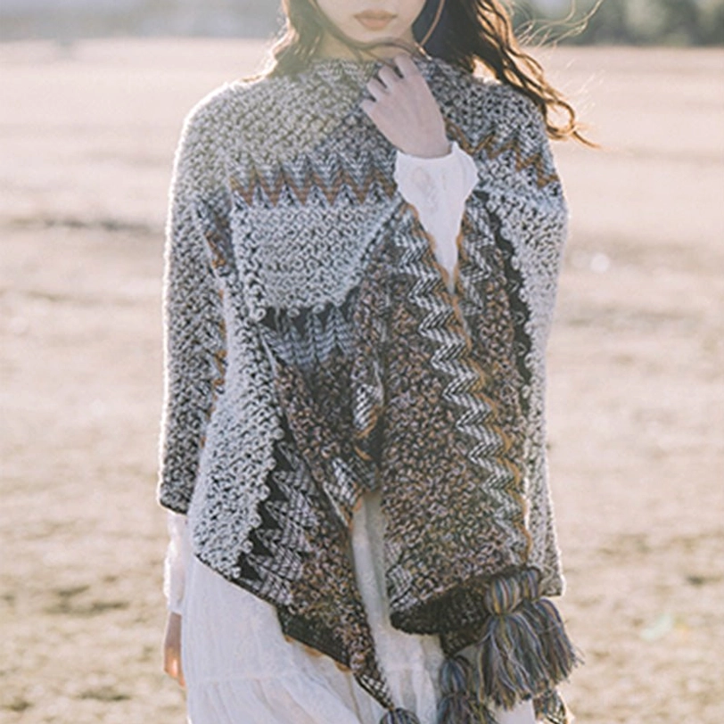 Close-up front view of Tibetan knit shawl featuring geometric patterns and thick decorative tassel hem details