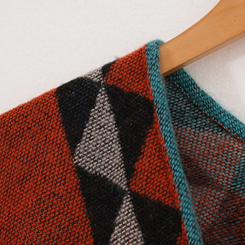 Overhead flat lay of geometric ethnic tassel shawl showing complete pattern design, rhombus motifs, and color distribution