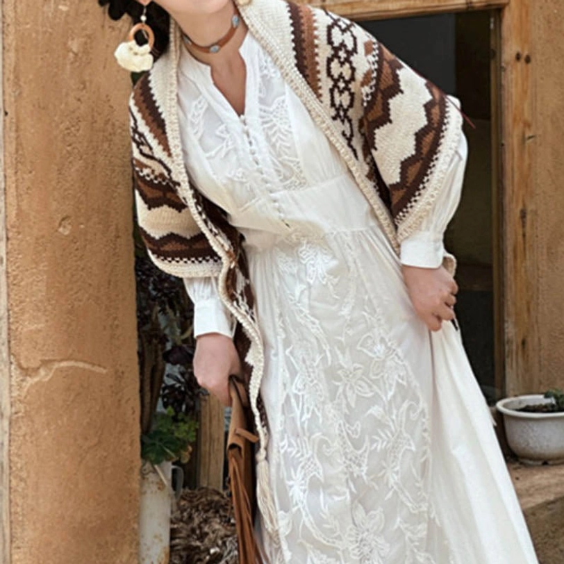 Tibetan boho shawl product flatlay, showcasing full geometric knit design and tassel fringe against neutral background