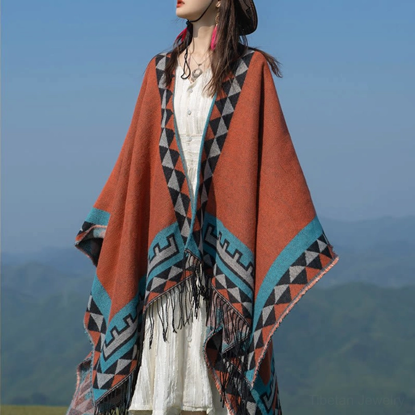Front right three-quarter view of ethnic geometric shawl with decorative collar trim, tassel hem, and white under-layer