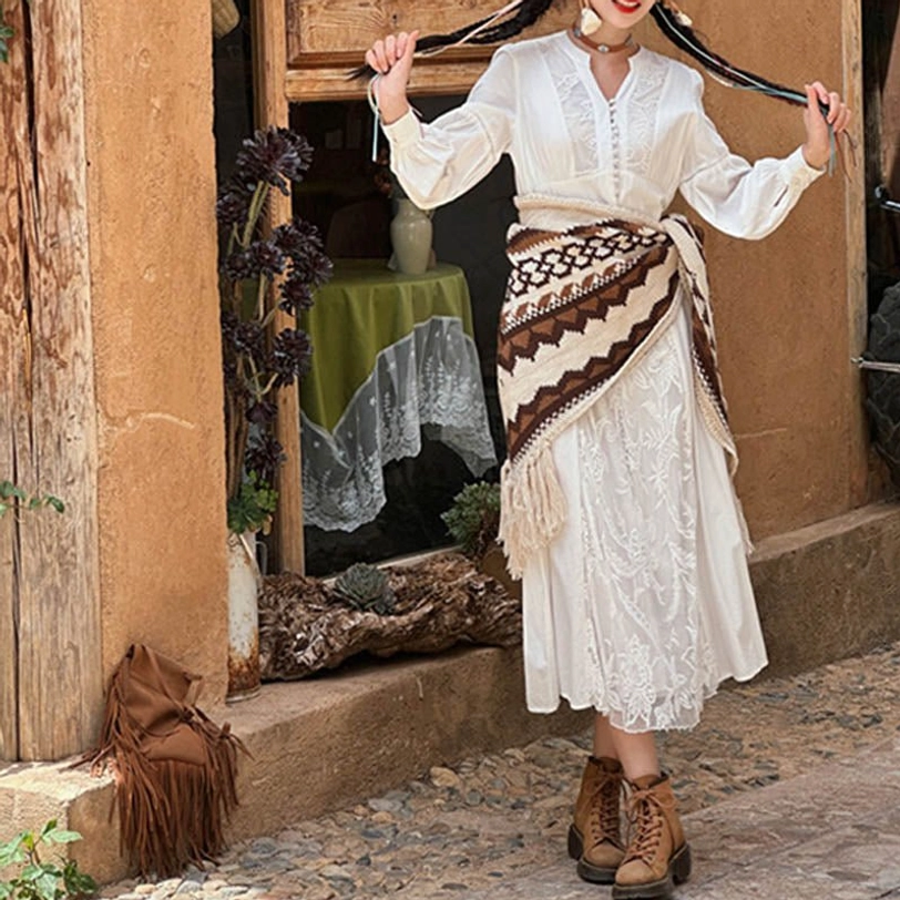 Geometric patterned Tibetan shawl wrapped around waist, front view at shop doorway with tassel details