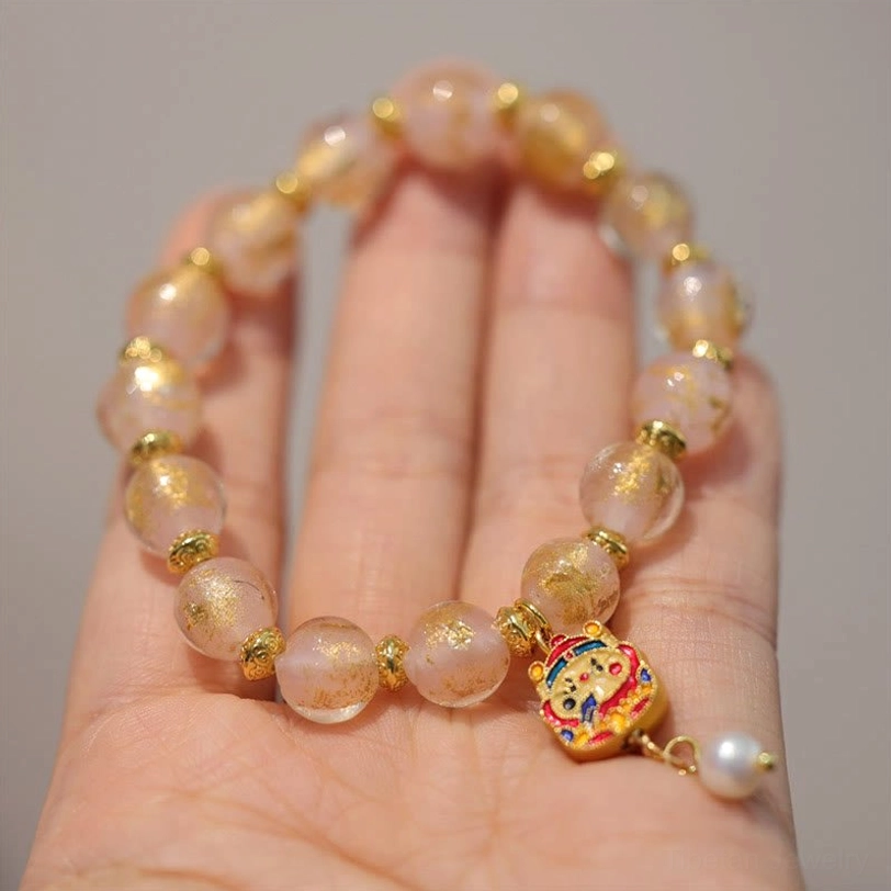 Golden bead Tibetan god of wealth charm bracelet worn on wrist from alternate angle with tiny end pendant visible, authentic wear demonstration
