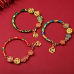 Tibetan gourd prosperity bracelets in multiple colors - red, blue, green, pink - with copper lion charms and fortune pendants on red background
