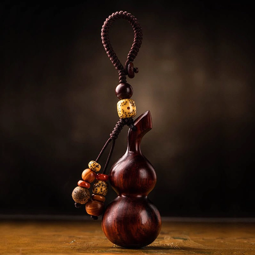 Premium ebony and red sandalwood gourd keychain with natural wood grain texture, close-up detail of hand-polished finish and protective spiritual design