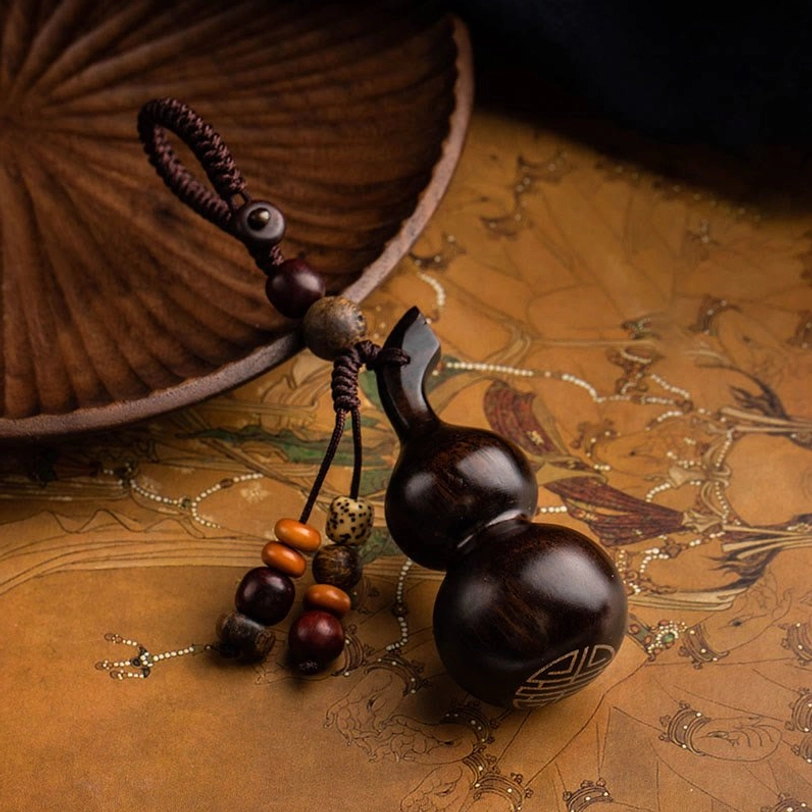 Handcrafted tibetan gourd keychain featuring sacred wood carving and artisan bead tassel, spiritual protection charm for daily meditation practice