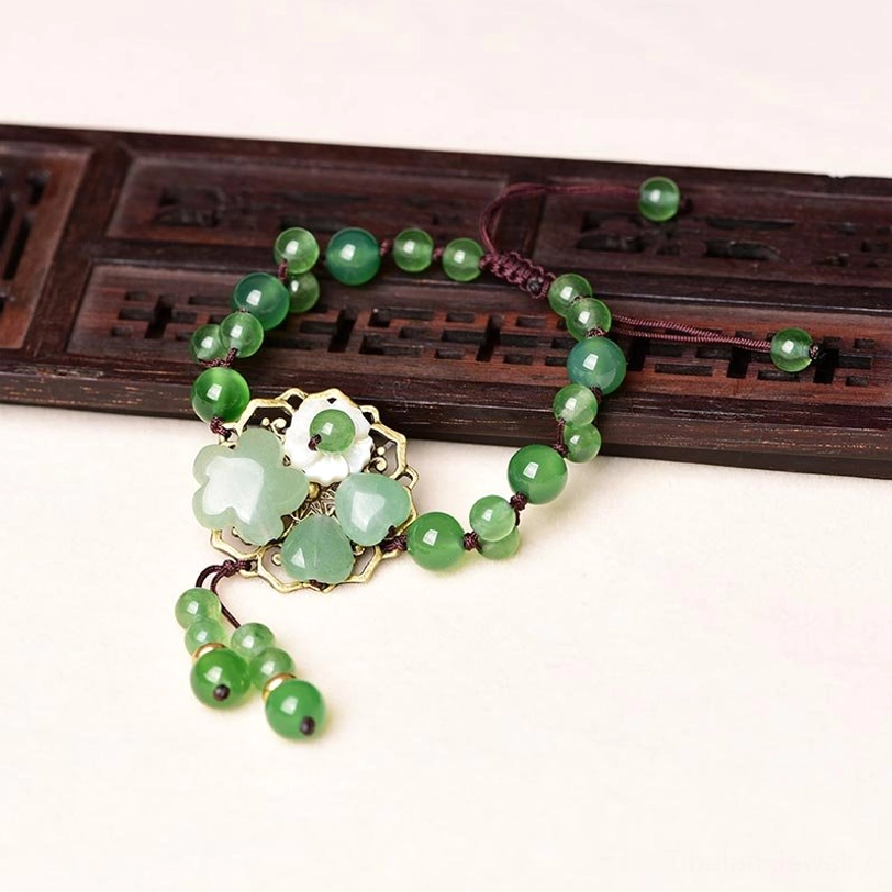 Tibetan-inspired green jade flower dangle bracelet with multiple stone types for energy balance