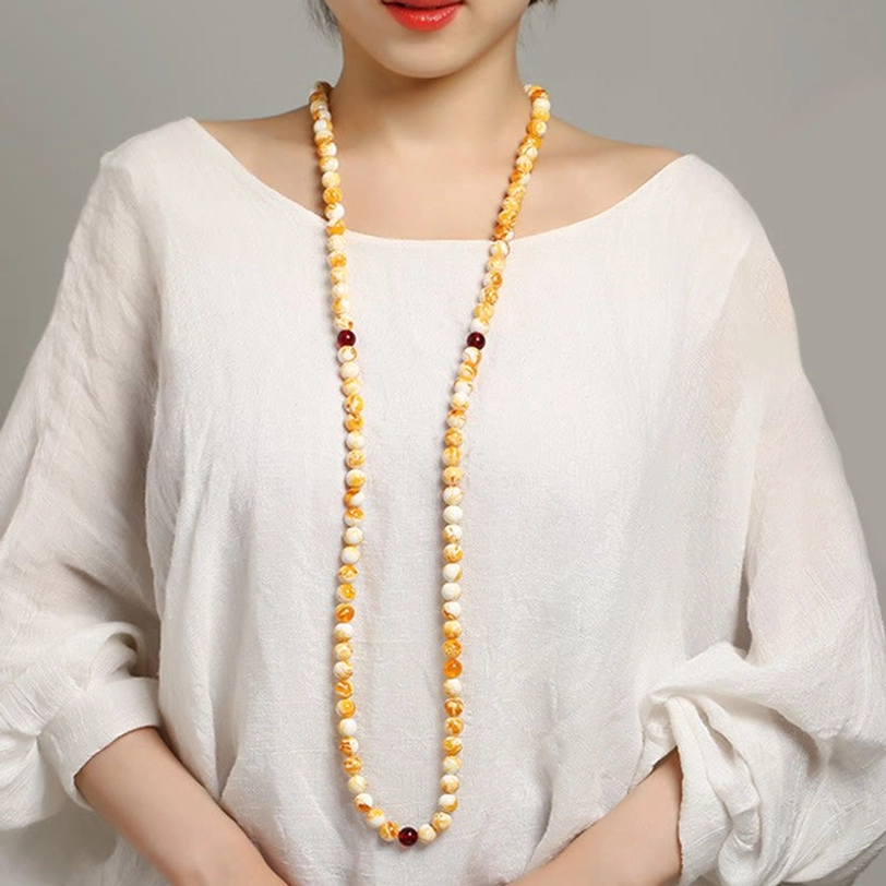 Handcrafted Tibetan 108-bead amber mala necklace with polished yellow and white beads, traditional prayer tool for meditation and mantra recitation