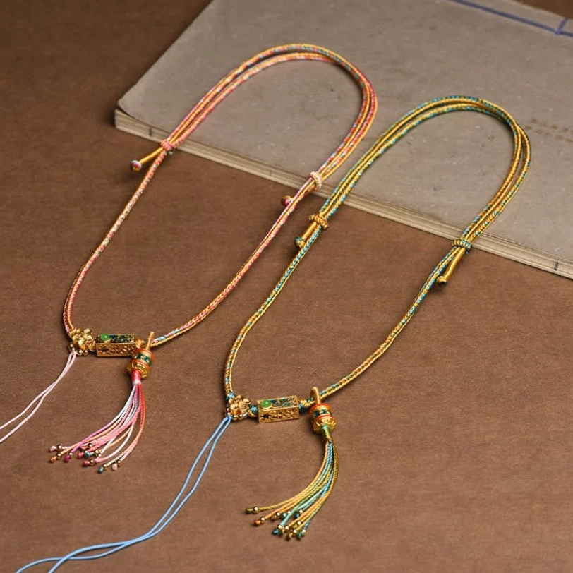 Tibetan handcrafted braided copper necklace with colorful rope and decorative charm talisman detail