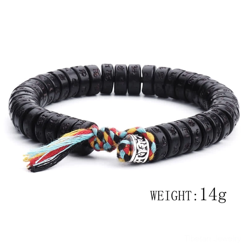 Handcrafted Tibetan Om Mani Padme Hum coconut shell bracelet three-quarter side angle with black engraved beads, silver charm, and vibrant tassel