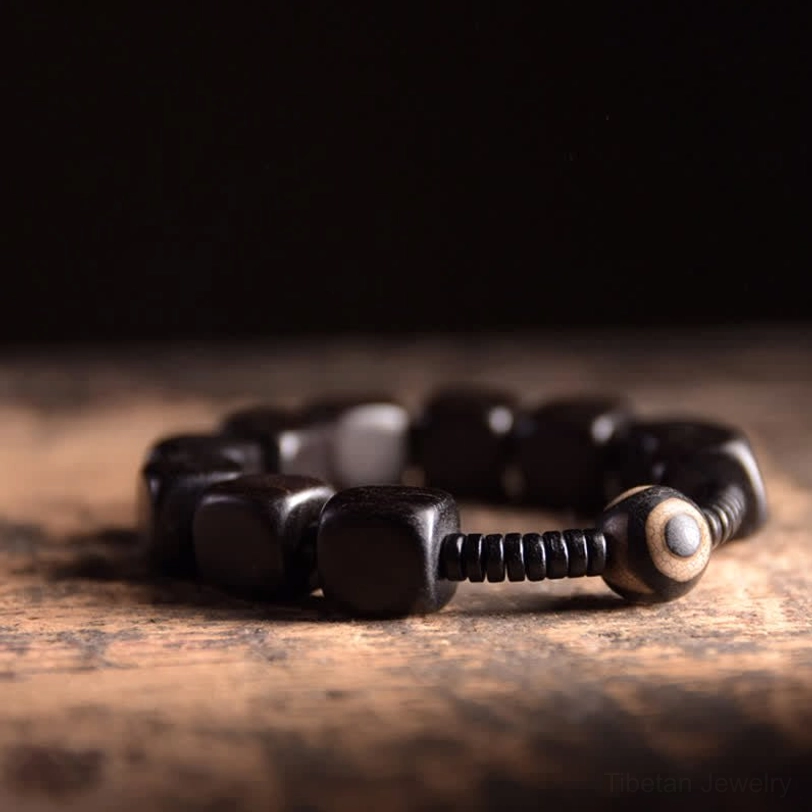 Handmade tibetan dzi bracelet side view showing quality square black wood beads spiral separators and single eye decorative dzi accent
