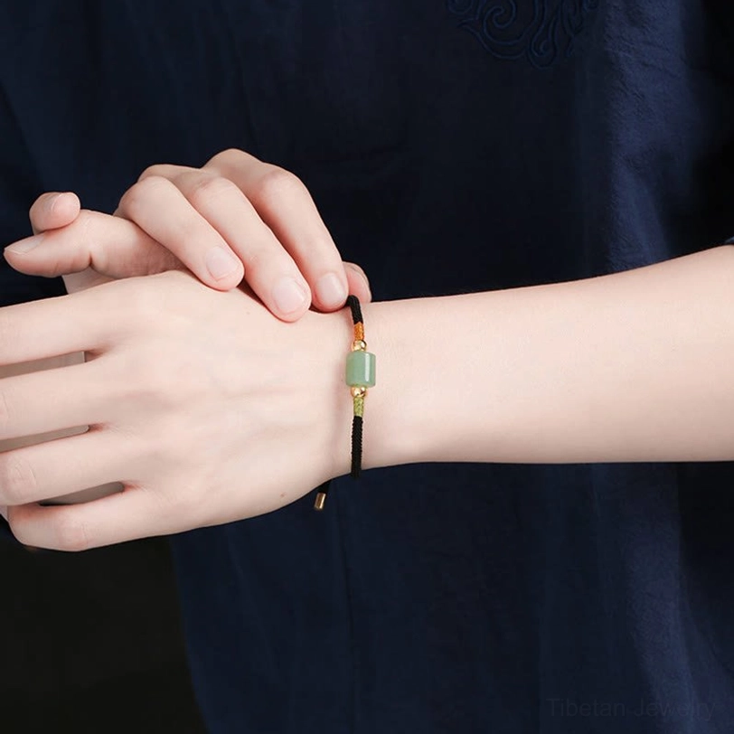 Tibetan protection bracelet handmade craftsmanship featuring braided red string, natural green aventurine bead, and copper-plated gold hardware