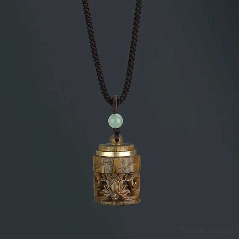 Handmade Tibetan green sandalwood pendant necklace in natural light, showing authentic wood grain and artisan craftsmanship